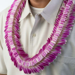 Layered purple and white orchid lei worn over a light collared shirt