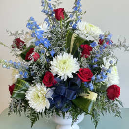 Red roses and white chrysanthemums in a white vase with blue flowers