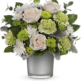 White and green floral arrangement in a clear glass vase