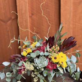 Mixed bouquet with yellow daisies, burgundy blooms, and a succulent in a wooden box