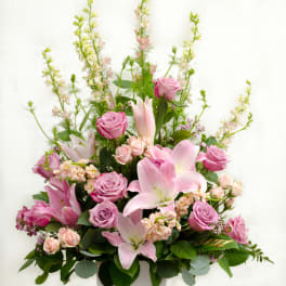 Pink roses and lilies arranged in a white vase