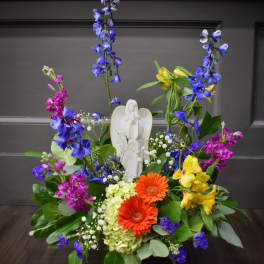 Colorful floral arrangement with an angel figurine in the center