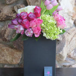 Pink and purple bouquet with roses, tulips, orchids, and hydrangea in a black box
