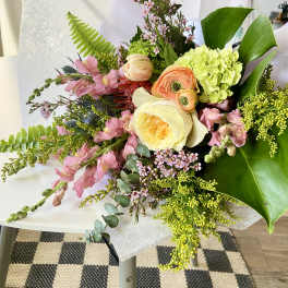 Mixed bouquet with pink and cream flowers in white paper