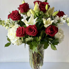 Red roses and white lilies arranged in a clear glass vase