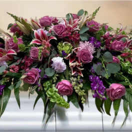 Large purple and pink floral casket spray with roses and lilies