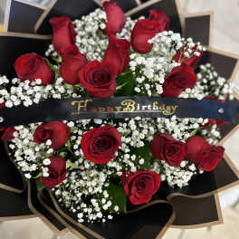 Bouquet of red roses with white baby's breath and a Happy Birthday ribbon
