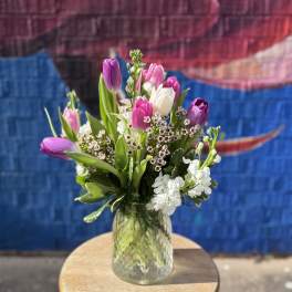 Bouquet of pink and purple tulips in a glass vase