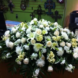 Large white floral casket spray with roses and lilies
