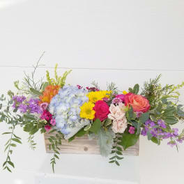 Colorful mixed flower arrangement in a wooden box