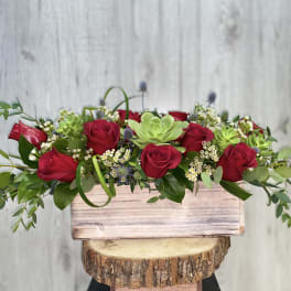 Red roses and succulents in a rustic wooden box