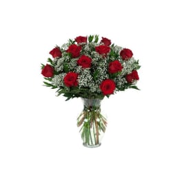 Bouquet of red roses and baby's breath in a clear glass vase