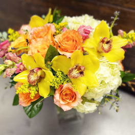 Bouquet of yellow orchids, peach roses, and white hydrangeas