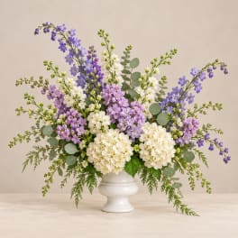 White and lavender flower arrangement in a white vase