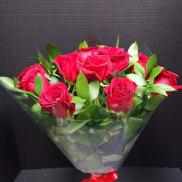 Bouquet of red roses wrapped in clear plastic with a red ribbon