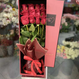 Boxed bouquet of red roses with a ribbon tie