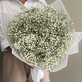 Large bouquet of tiny white flowers wrapped in white paper