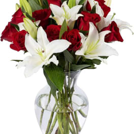 Red roses and white lilies arranged in a clear glass vase