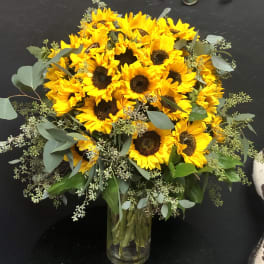 Bouquet of yellow sunflowers in a clear glass vase