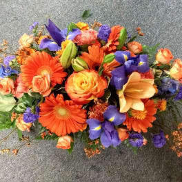 Colorful mixed bouquet with orange gerberas, roses, and purple irises
