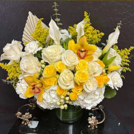 Yellow and white floral arrangement in a glass vase