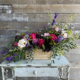 Mixed bouquet in a wooden box with pink, purple, and white flowers