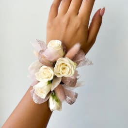 Cream rose wrist corsage with pink ribbon and mesh accents