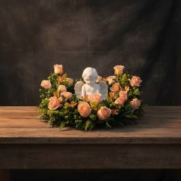 Peach rose wreath with a white angel figurine in the center