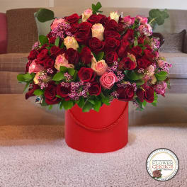 Large bouquet of red and pink roses in a red hat box