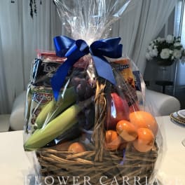 Gift basket with fruit, snacks, and a blue ribbon