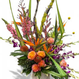 Tall tropical arrangement with orange roses and purple orchids in a vase