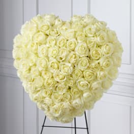 Heart-shaped arrangement of pale yellow roses on a stand
