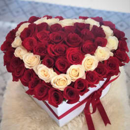 Heart-shaped box filled with red and white roses