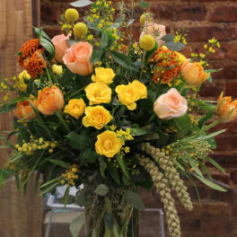 Bouquet of yellow and peach roses in a glass vase