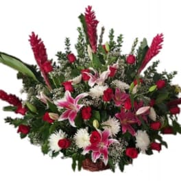 Large basket arrangement of red roses, pink lilies, and white mums with tall red tropical blooms