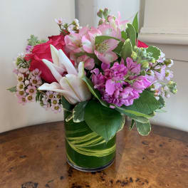 Pink and white mixed bouquet in a green glass vase