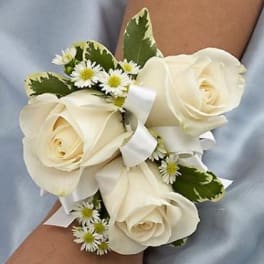 White rose wrist corsage with small daisy accents and ribbon