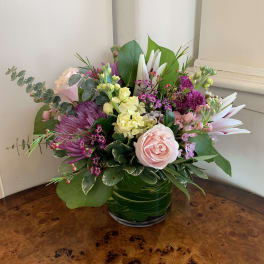 Pink and purple floral arrangement in a glass vase