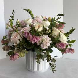 Pink and white floral arrangement in a ribbed white vase