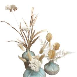 Three dried floral arrangements in blue ceramic vases