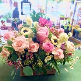 Mixed pink and cream flower arrangement in a basket