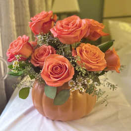 Orange roses arranged in a pumpkin-shaped vase