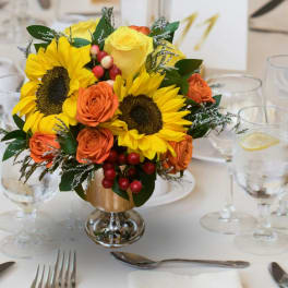 Sunflower and orange rose arrangement in a gold vase