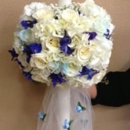 White floral candle with blue accents and tulle drape