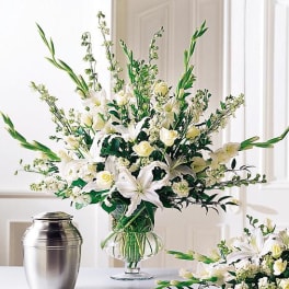 White floral arrangement in a clear glass vase with tall green stems