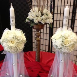 White floral wedding candles with rose arrangements and tulle