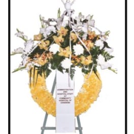Standing funeral wreath with white and yellow flowers on an easel