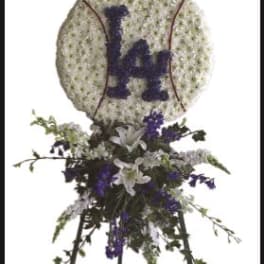 Baseball-shaped floral tribute on an easel with purple and white flowers