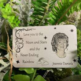 Artificial greenery with a memorial card reading "Love you to the Moon and Stars"