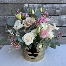 Mixed bouquet of pink and white roses in a gold vase